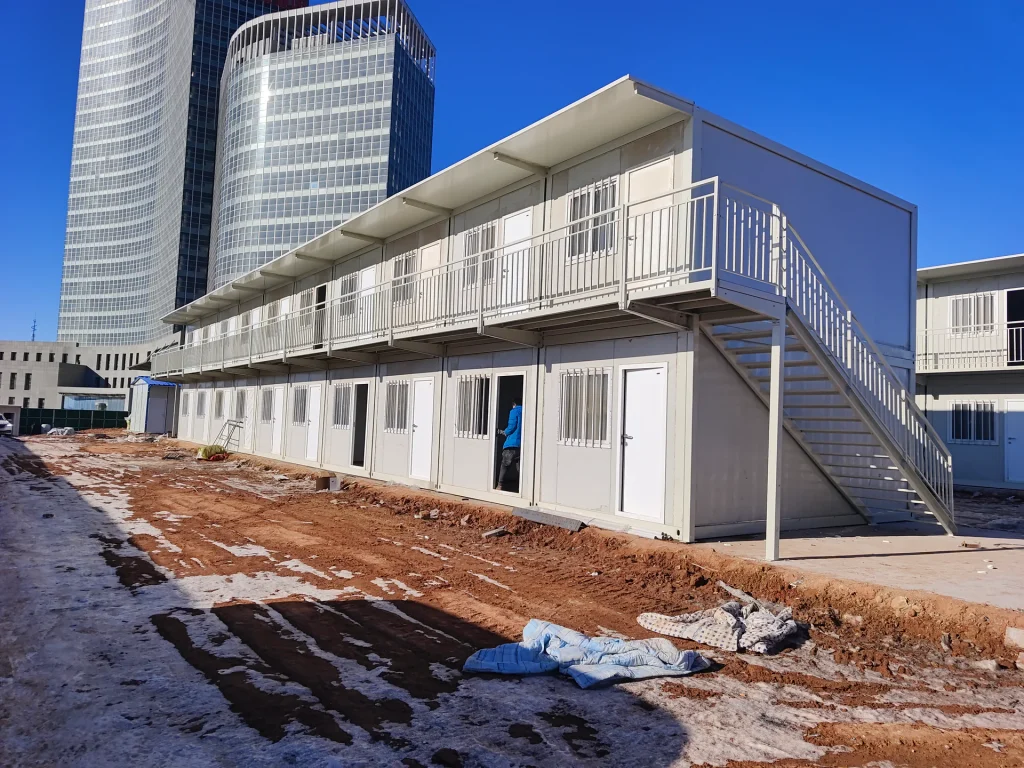 Rows of prefabricated worker dormitory buildings in a construction camp