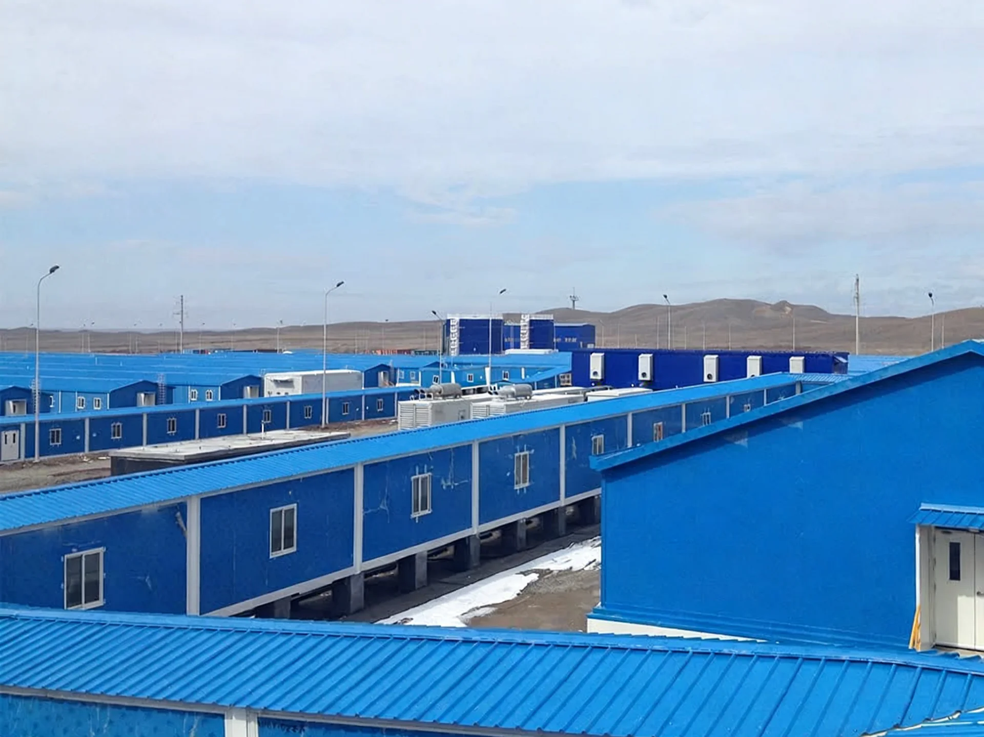 Blue modular dining, kitchen and recreation support buildings in a remote mining camp