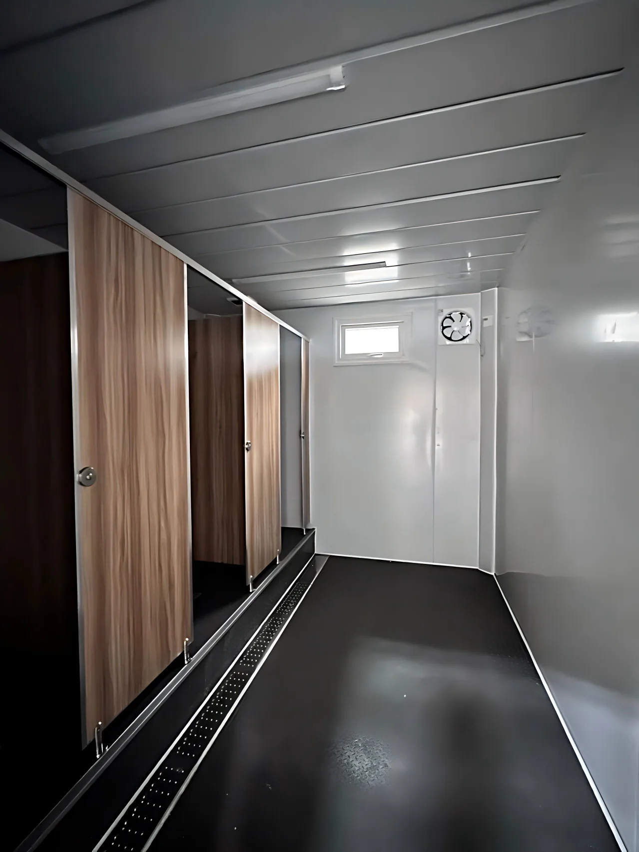 Centralized modular bathroom interior with private cubicles and drainage channel