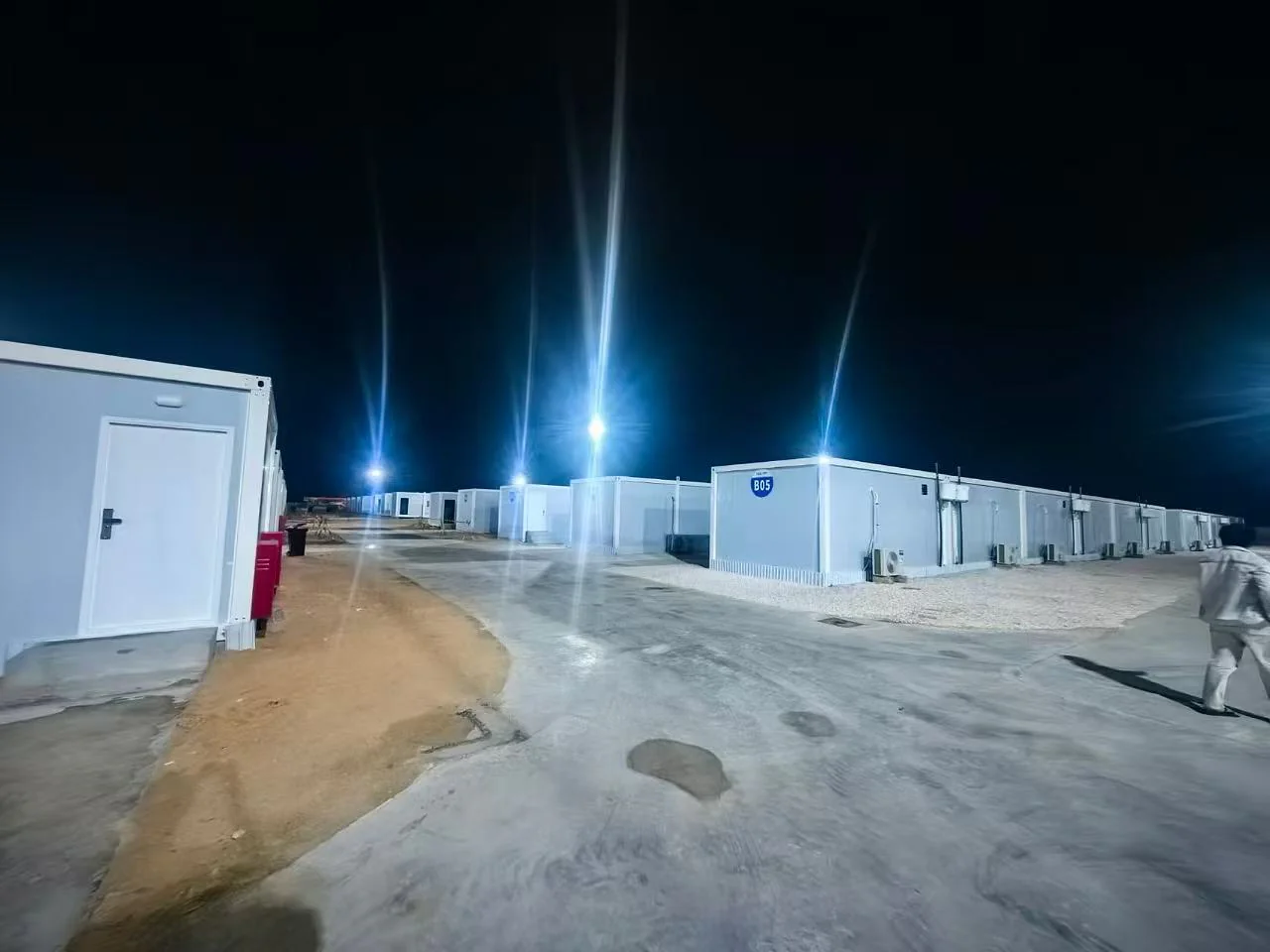 Illuminated modular workforce camp buildings and internal roads at night