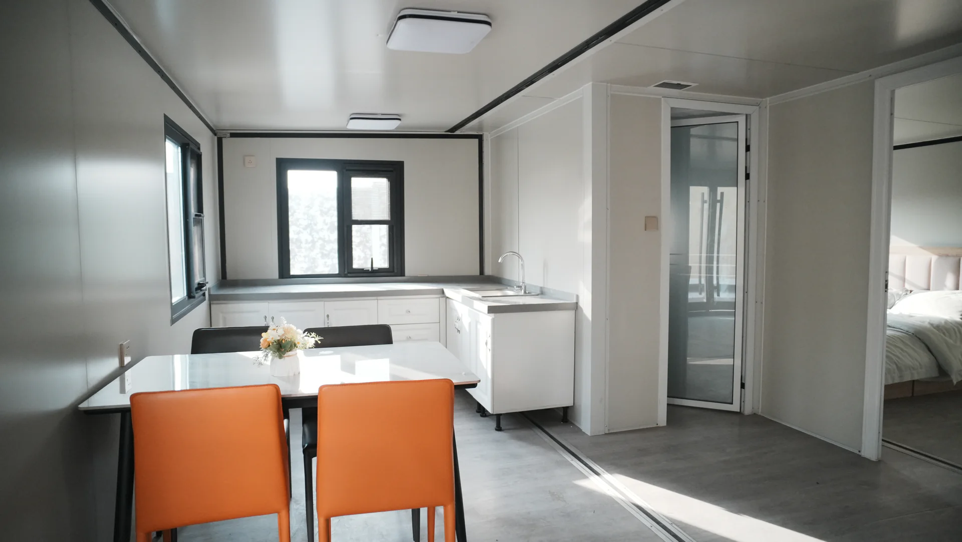 KUBO sample interior with kitchen cabinets, sink, dining furniture, partitions and a bedroom