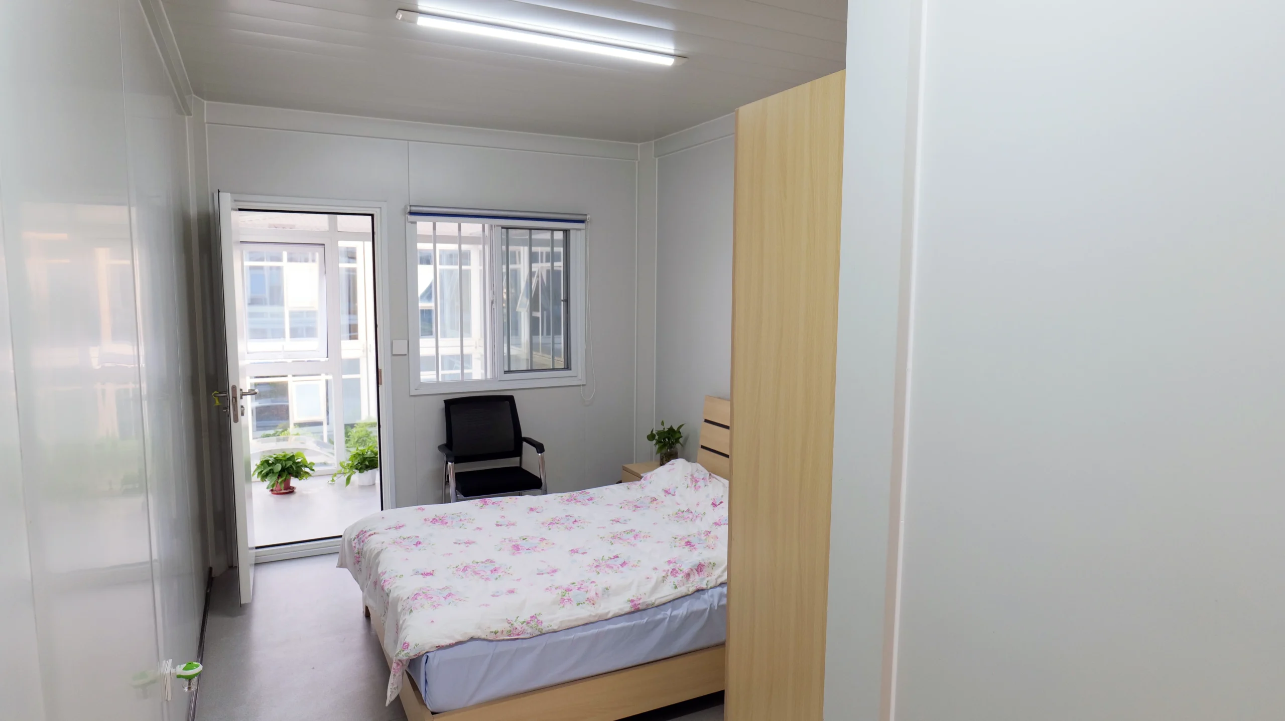 Single-room modular mining camp dormitory interior with bed wardrobe window and desk chair