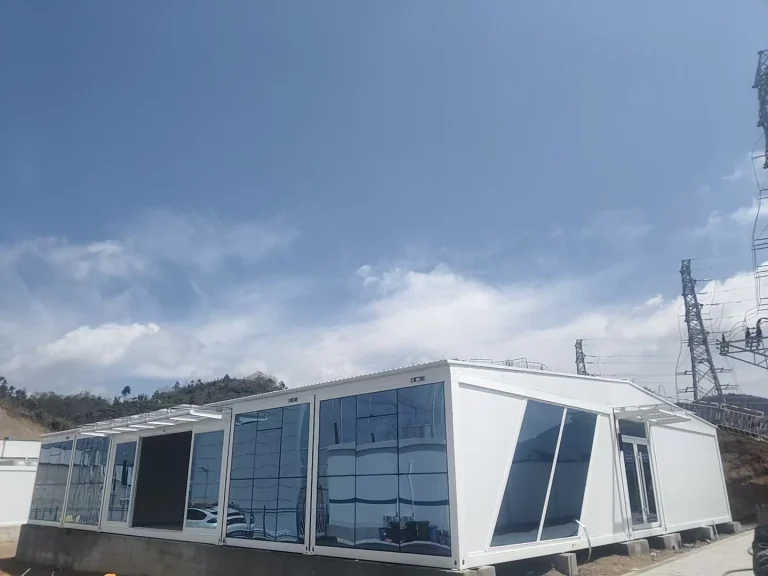 Completed modular site building beside high-voltage infrastructure at a remote project