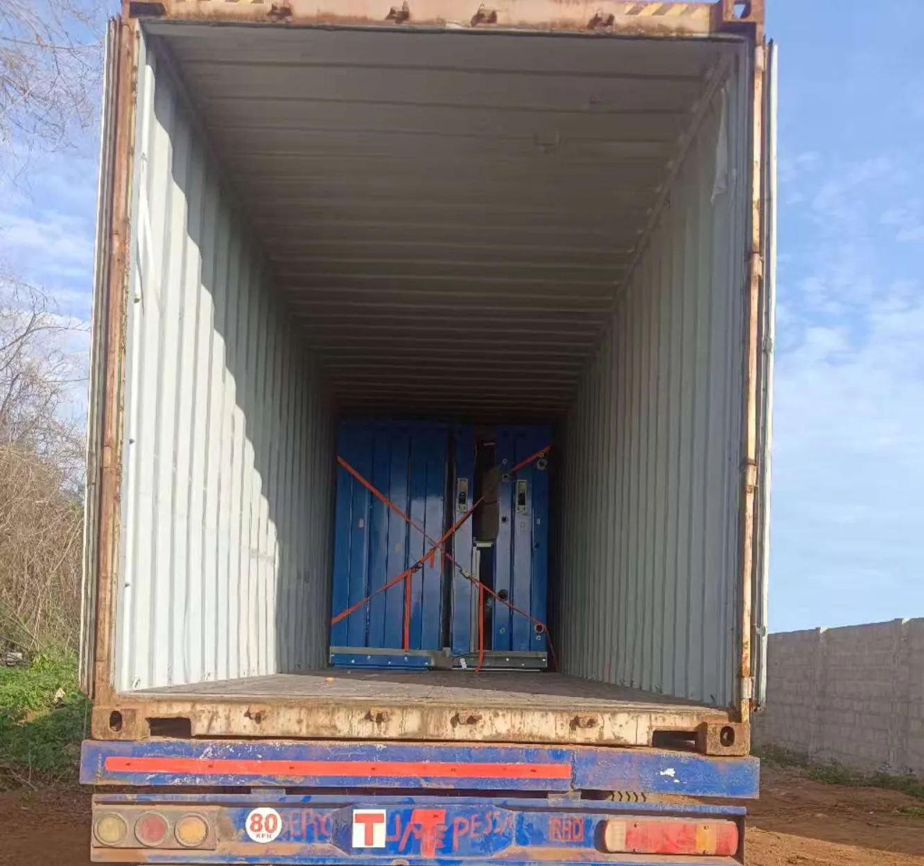 Modular frame components restrained inside a freight container at destination