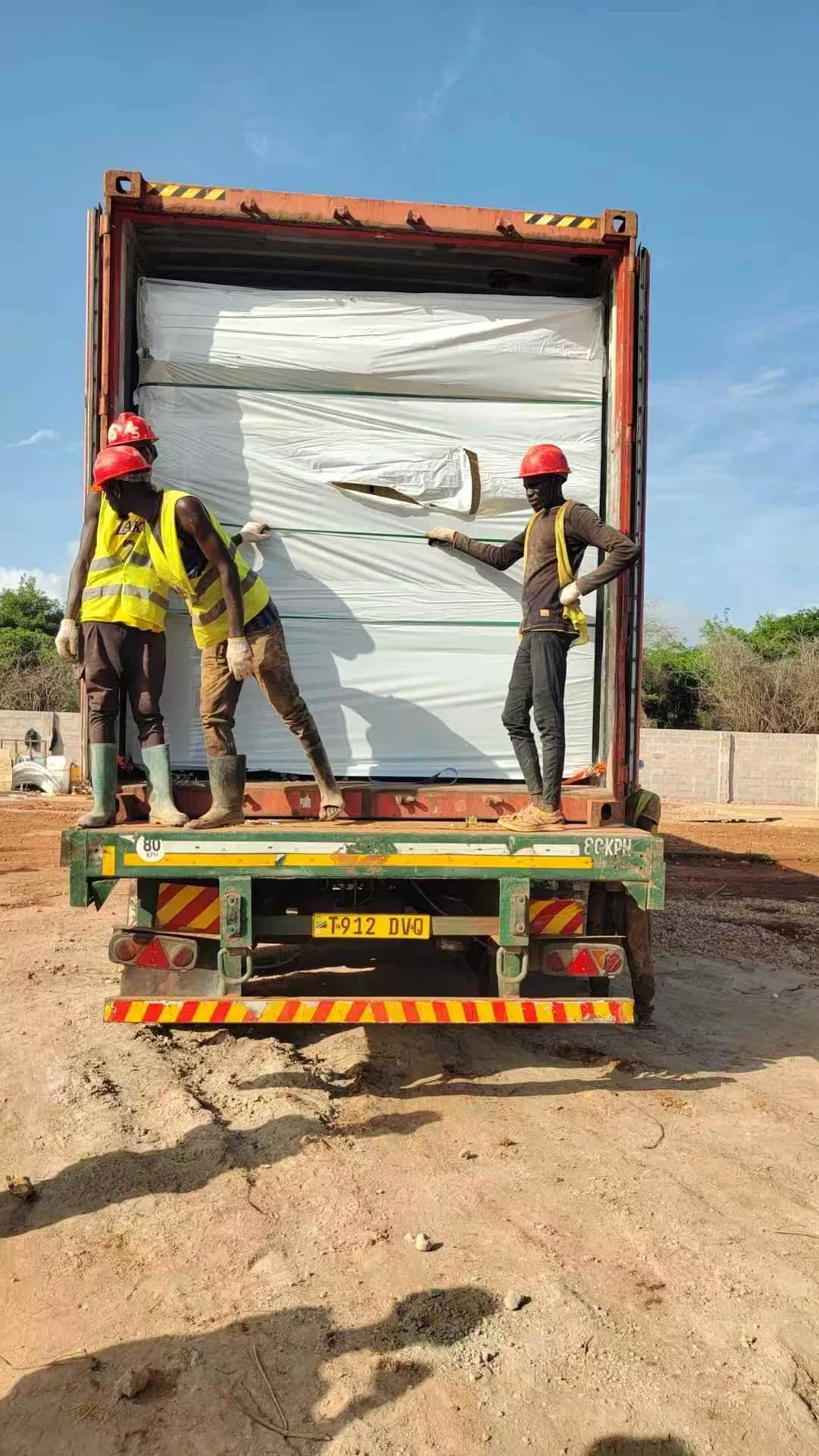 Vertical modular structural member being lifted into a staged frame at a project site